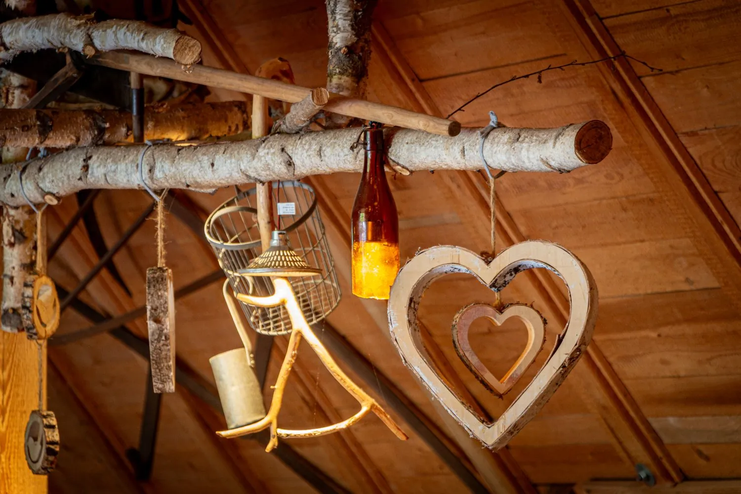 Holzherz und Flaschenlaterne an Birkenast