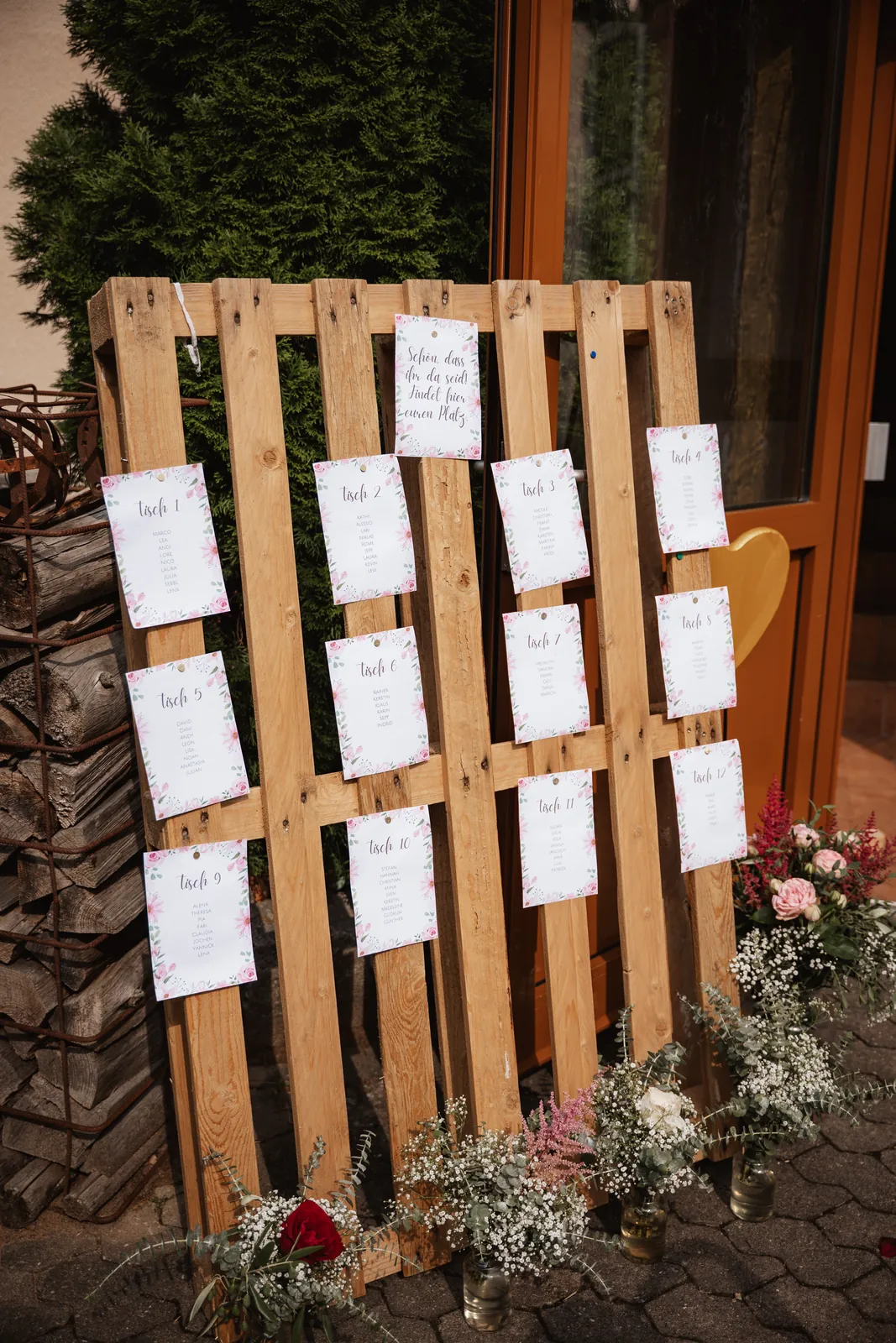 Sitzplan auf einer Holzpalette mit Blumen